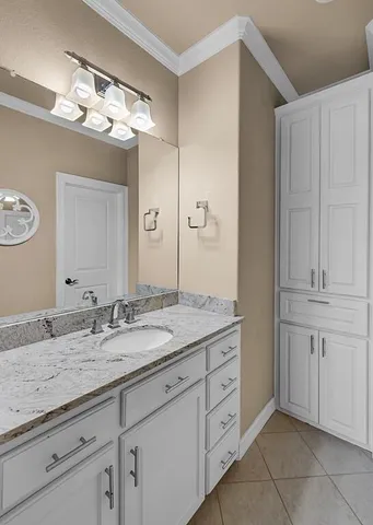 a bathroom with a granite countertop double vanity sink and mirror