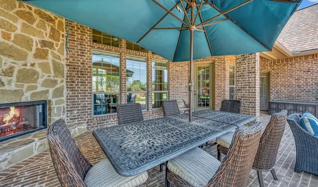 a view of a roof deck with table and chairs under an umbrella
