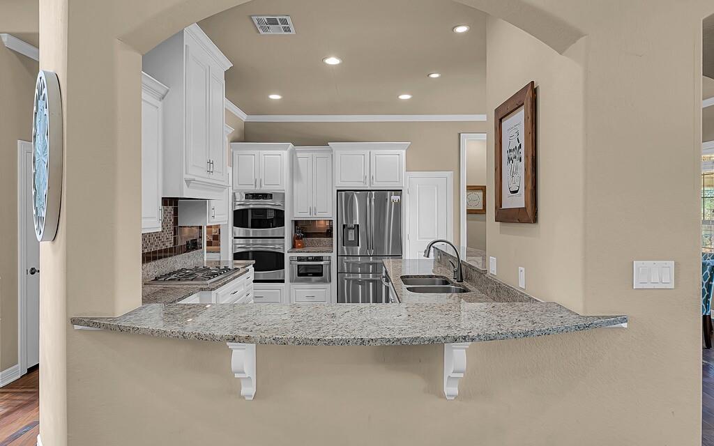 74 Independence Trail Waco, TX 76708 - Photo 9 of 40 a kitchen with stainless steel appliances granite countertop a sink stove and refrigerator