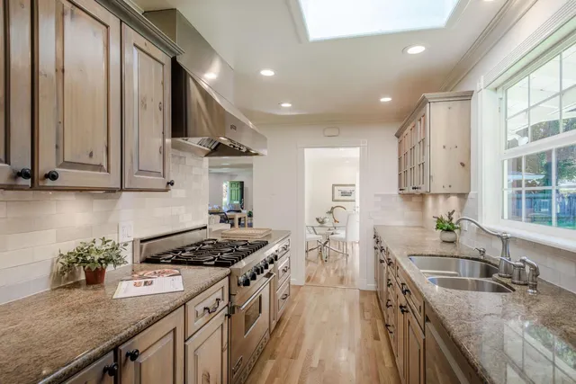 a kitchen with stainless steel appliances granite countertop a sink stove and cabinets