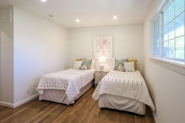 a bedroom with two beds and a window