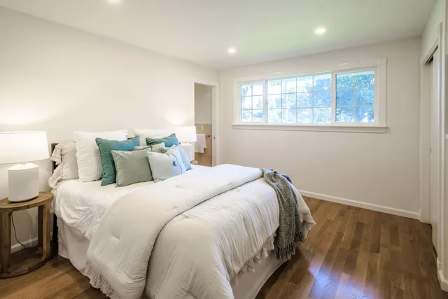a bedroom with a bed and wooden floor