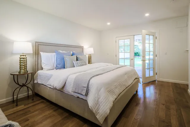 a large bed sitting in a bedroom next to a window