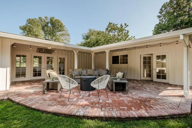 a view of a house with backyard and sitting area