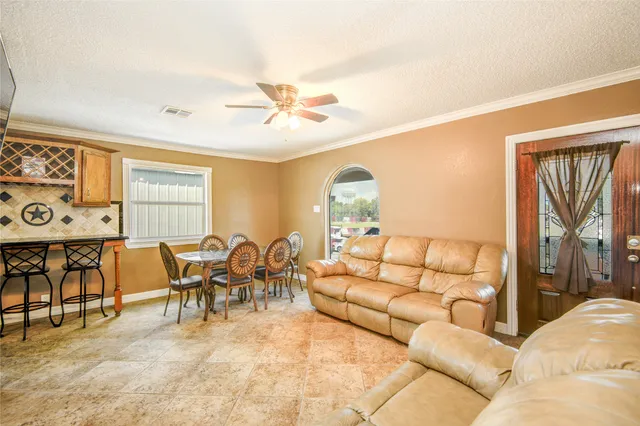 a living room with furniture a chandelier and a dining table