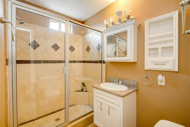 a bathroom with a sink and mirror with a shower