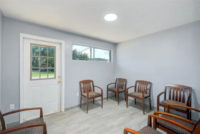 a view of a workspace with furniture and a window