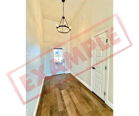 a view of an empty room with fireplace and window