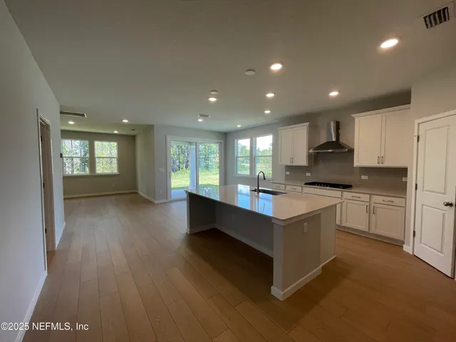 a kitchen with a stove and white cabinets