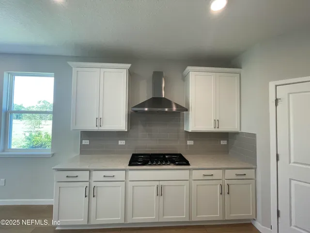 a view of kitchen with kitchen island wooden floors and stainless steel appliances