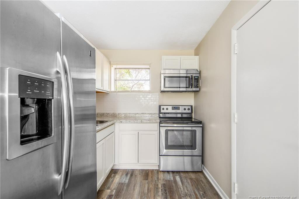 4305 Rosehill Road, Unit D D Fayetteville, NC 28311 - Photo 3 of 10 a kitchen with stainless steel appliances granite countertop a stove and a refrigerator