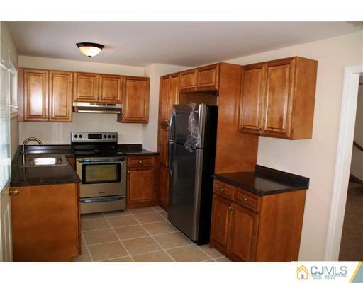 495 Harding Road Old Bridge, NJ 08879 - Photo 2 of 11 a kitchen with a refrigerator and a stove