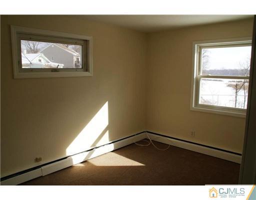 495 Harding Road Old Bridge, NJ 08879 - Photo 6 of 11 a view of an empty room with wooden floor and a window