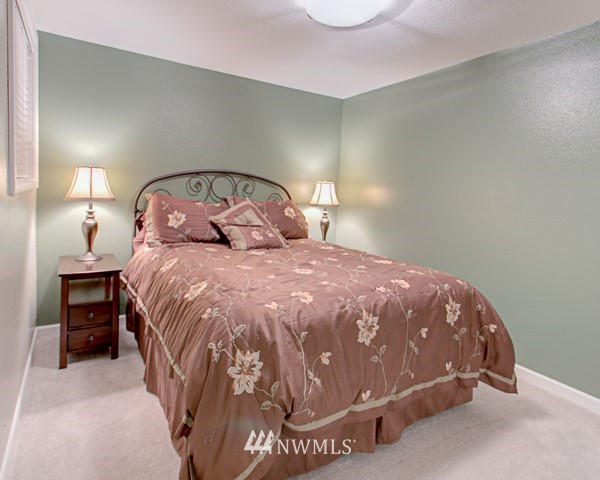 2219 West Bench Road Othello, WA 99344 - Photo 22 of 25 a large bed sitting in a bedroom next to a lamp