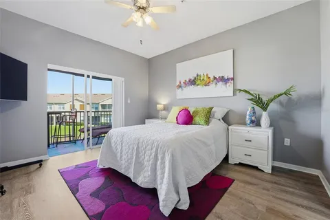a bedroom with a large bed and a flat tv screen on dresser