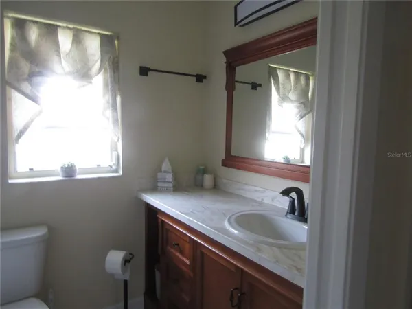 a bathroom with a granite countertop sink and a mirror