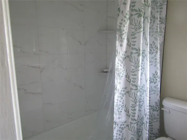 a bathroom with a toilet and shower curtain