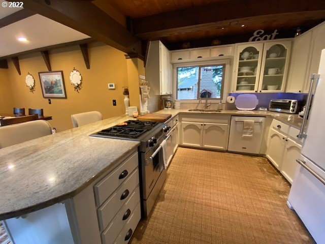 41945 Southeast Dover Court Sandy, OR 97055 - Photo 4 of 32 a large kitchen with stainless steel appliances granite countertop a stove a sink dishwasher and white cabinets with wooden floor
