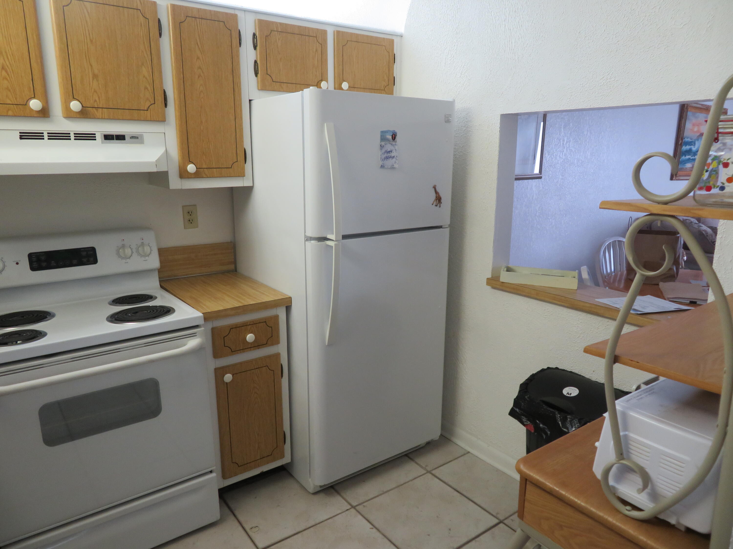 9233 Southwest 8th Street, Unit 119 Boca Raton, FL 33428 - Photo 25 of 42 a kitchen with a refrigerator and a stove