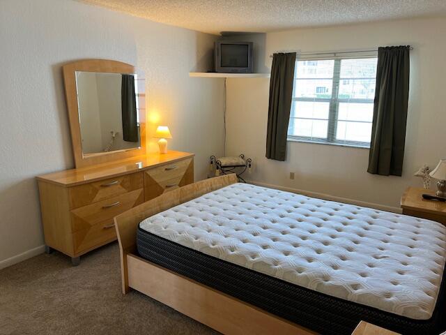 9233 Southwest 8th Street, Unit 119 Boca Raton, FL 33428 - Photo 32 of 42 a bedroom with a bed and dresser with mirror