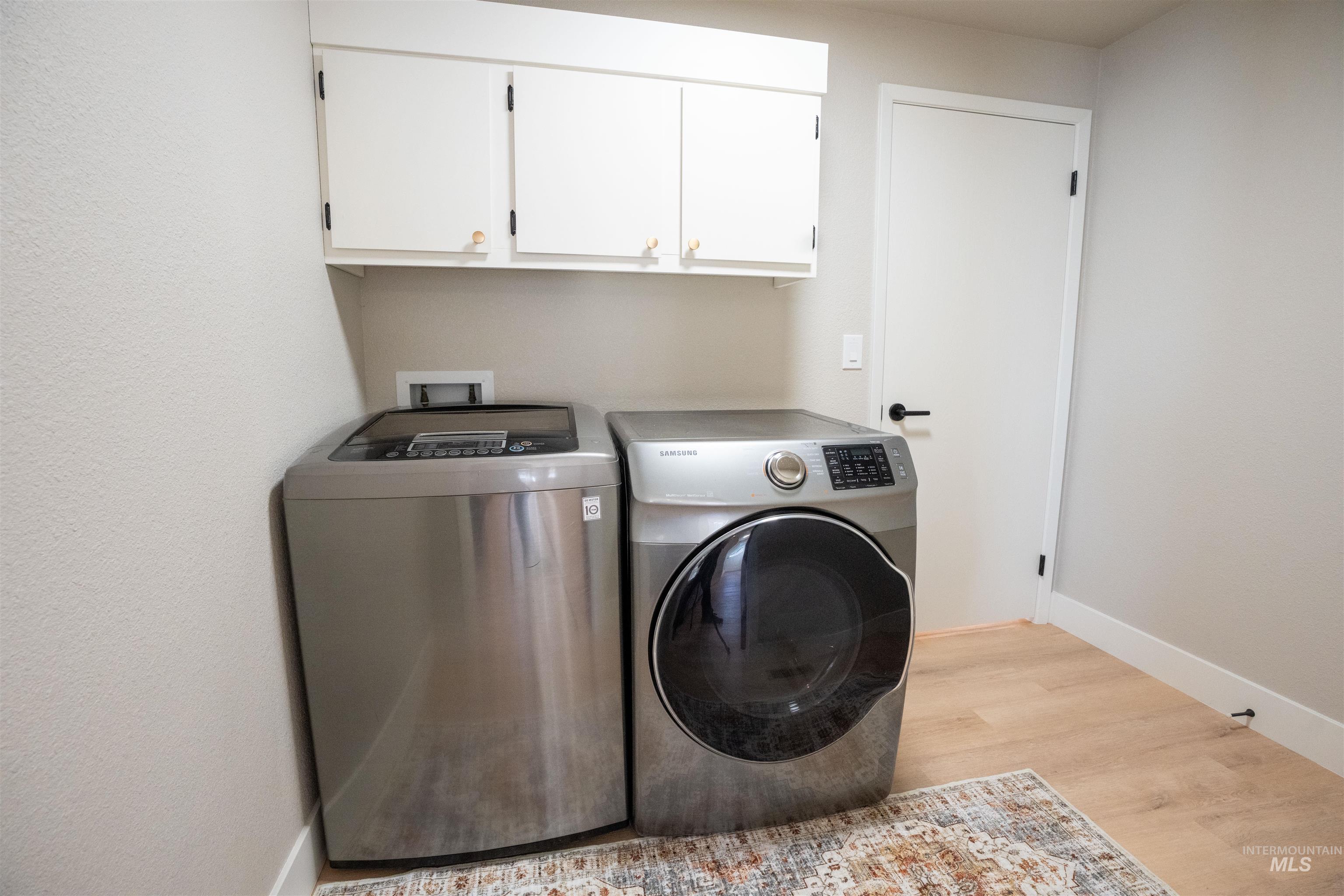 4667 Shawnee Way Boise, ID 83709 - Photo 16 of 24 Laundry area with separate washer and dryer, light wood-style flooring, and cabinet space