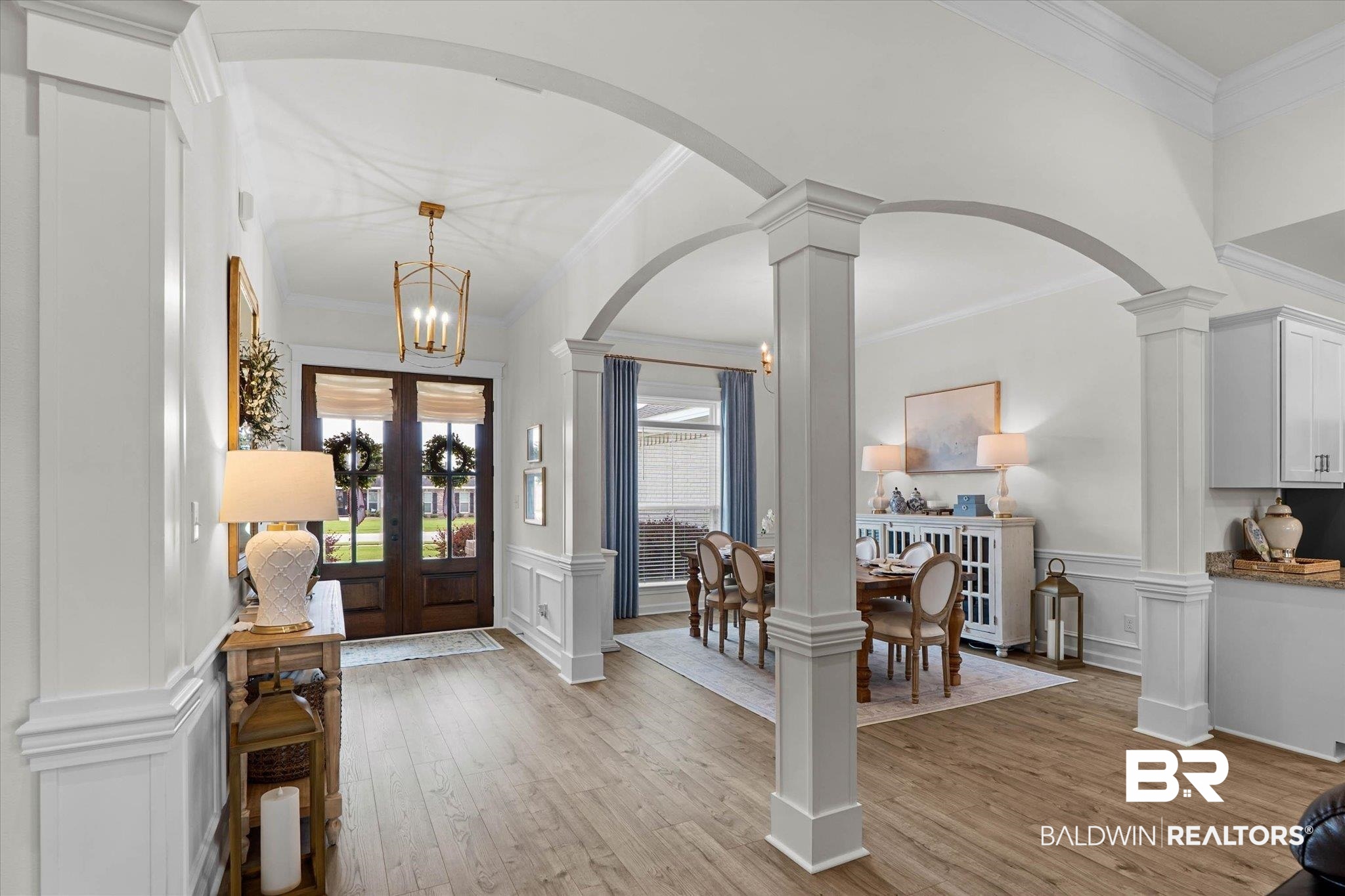 9074 Moses Way Theodore, AL 36582 - Photo 5 of 52 Entryway featuring warm wood-finish flooring, an arched doorway, and decorative columns