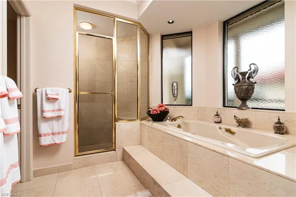 a bathroom with a tub sink and mirror