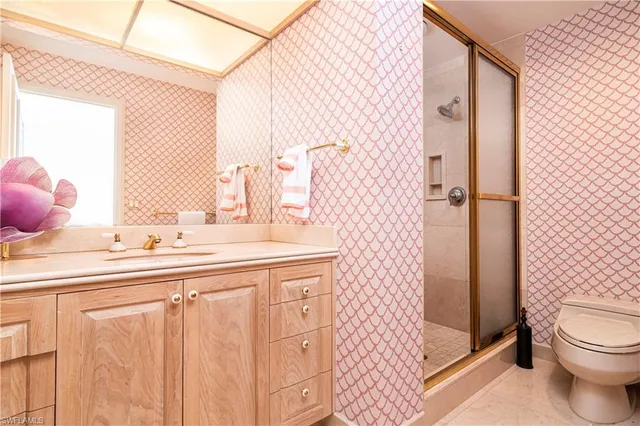 a bathroom with a sink a toilet and shower