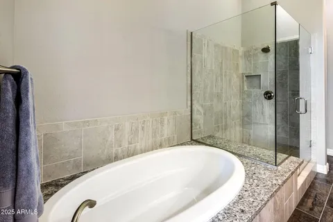 a bathroom with a granite countertop tub sink double vanity granite tub shower and mirror
