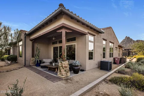 a living room with patio furniture and a potted plant