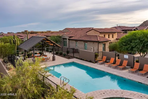 an aerial view of a house with pool and a yard