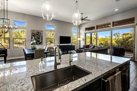 an open kitchen with granite countertop a table chairs and a chandelier