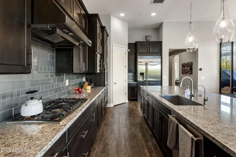 a kitchen with a sink a counter top space dining table and chairs