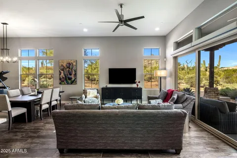 a living room with furniture kitchen view and a chandelier