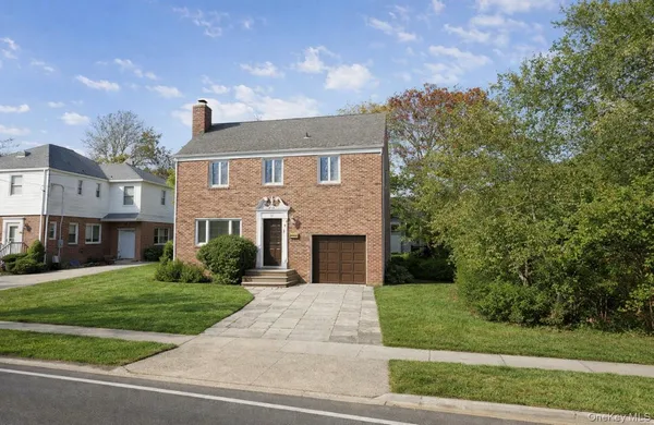 a front view of a house with yard and green space