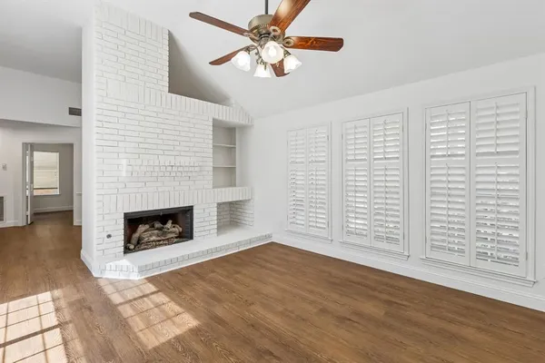 an empty room with windows and a fireplace