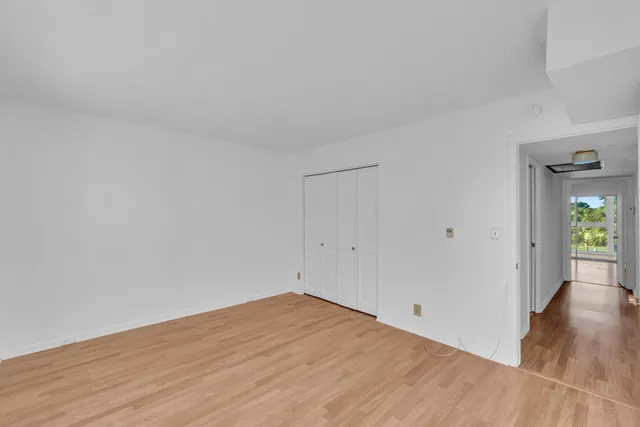 a view of empty room with wooden floor