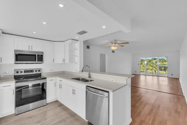 a kitchen with a sink stainless steel appliances and cabinets