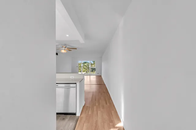 a view of a hallway with wooden floor and staircase