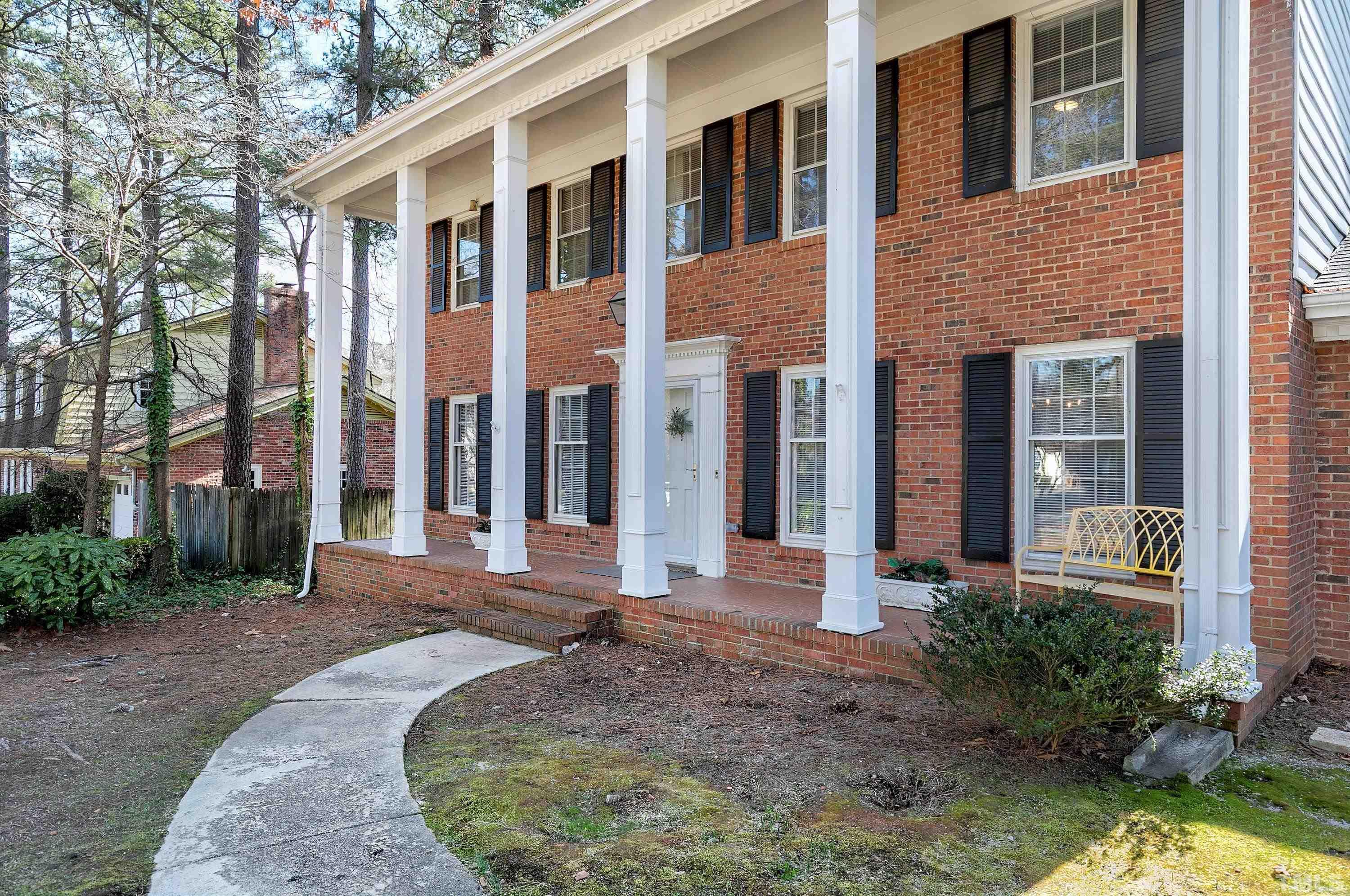 2012 Port Royal Road Raleigh, NC 27609 - Photo 2 of 36 a view of a house with brick walls plants and large tree