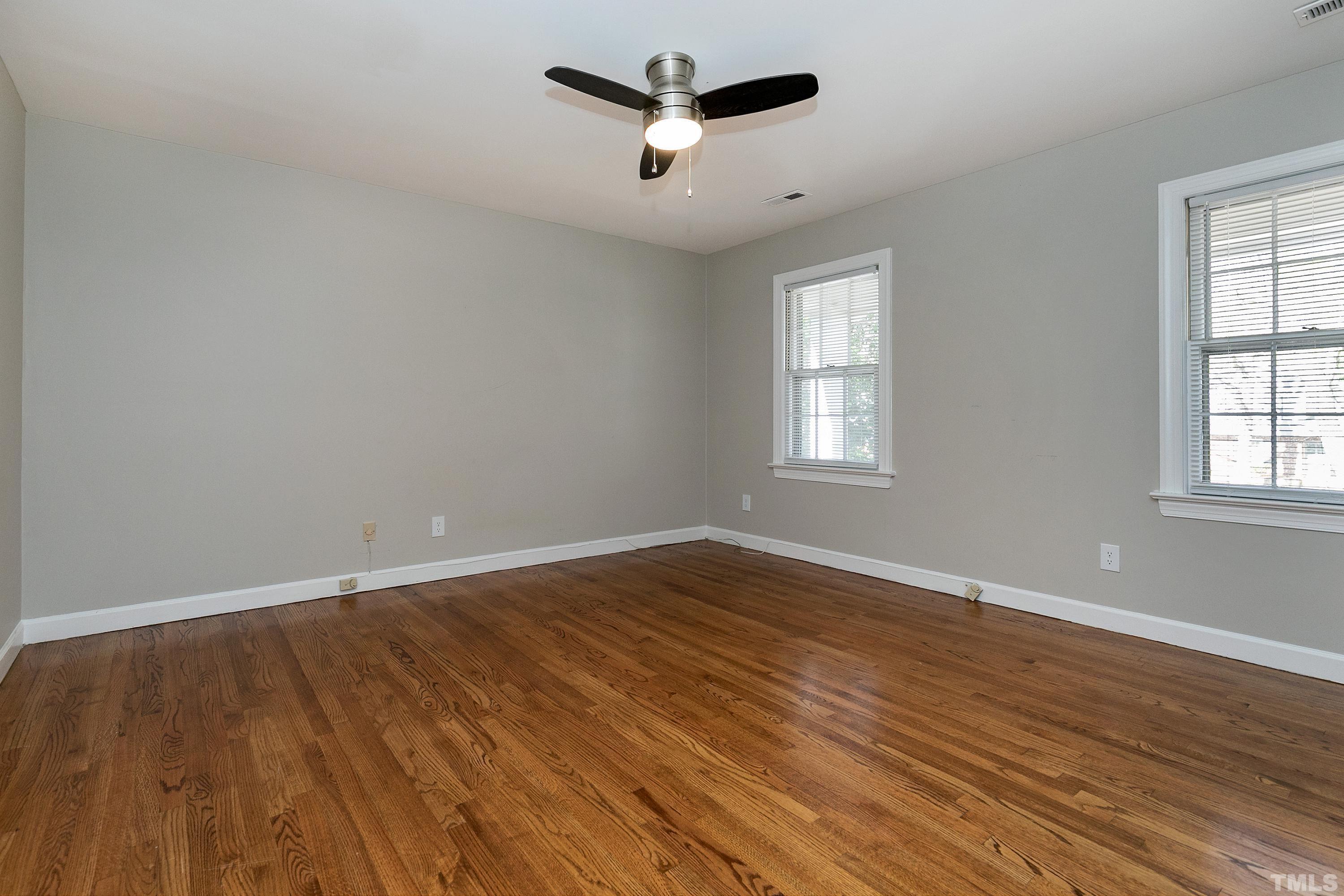 2012 Port Royal Road Raleigh, NC 27609 - Photo 28 of 36 an empty room with wooden floor ceiling fan and windows