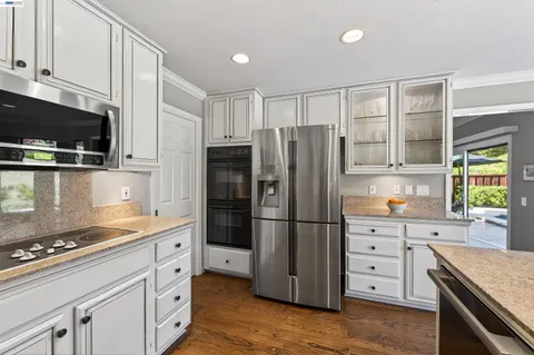 a kitchen with stainless steel appliances a stove a refrigerator a sink a stove and cabinets