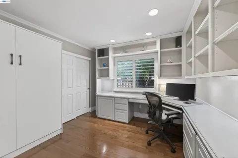 a view of a workspace with furniture and a window