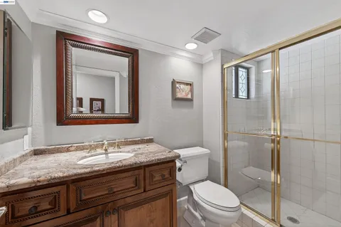 a bathroom with a granite countertop sink toilet and shower