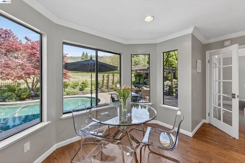 a dining room with furniture window and wooden floor