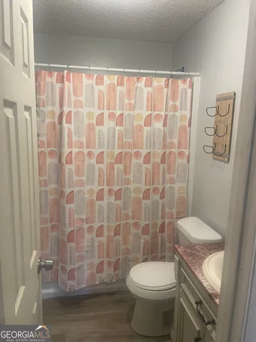 a white toilet sitting next to a shower curtain