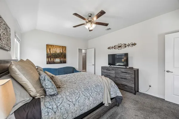 a bedroom with a large bed and a tv