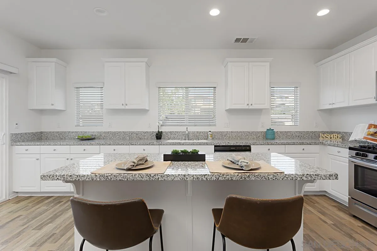258 Windsor Grey Way Fallbrook, CA 92028 - Photo 13 of 44 a kitchen with stainless steel appliances granite countertop a stove a sink and a granite counter tops
