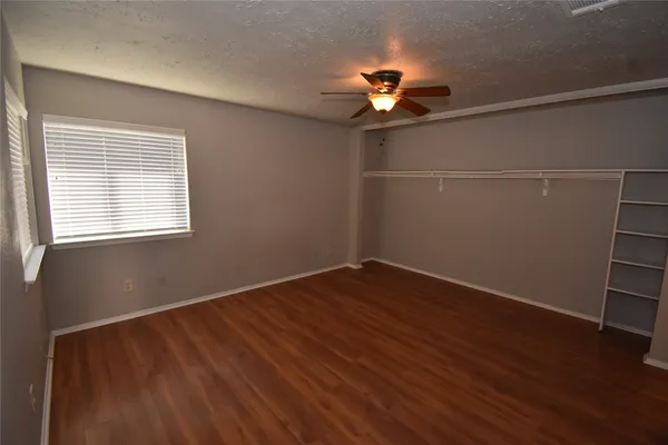 a view of a room with wooden floor and chandelier fan