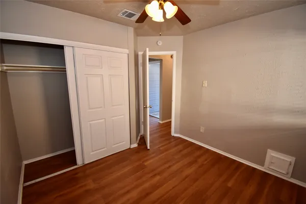 an empty room with wooden floor cabinet and closet
